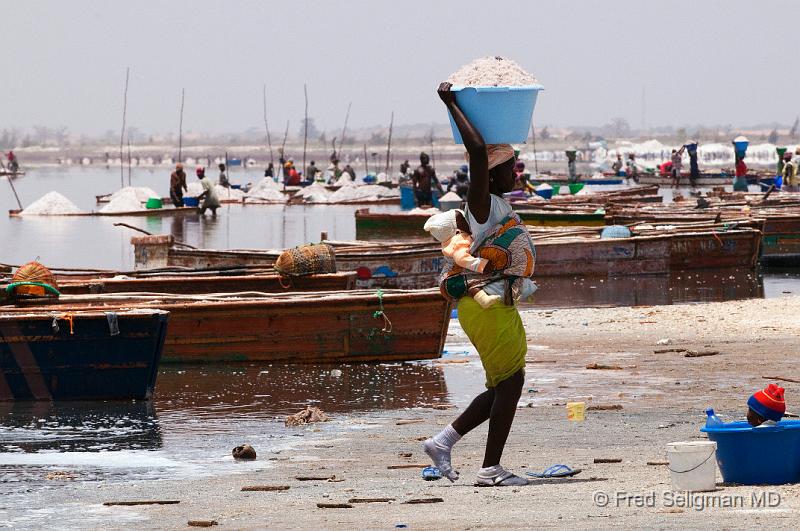 20090529_143639 D300 P1 S1.jpg - Lady not only carrying basin full of salt on her head but also has a baby on her back.  Note also the baby in the basin in lower right of photo